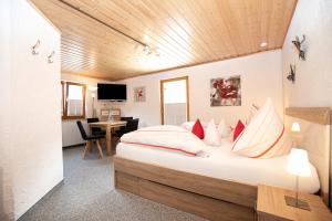 巴特欣德朗艾玛迪斯餐厅酒店的一间卧室配有一张带红色和白色枕头的大床