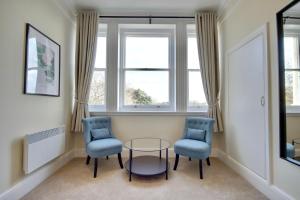 南安普敦The Mansion的带窗户的客房内配有两把椅子和一张玻璃桌