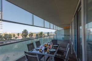 巴塞罗那Unique Rentals-Seafront Luxe Suites的阳台的用餐室配有桌椅