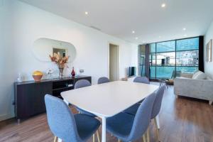 巴塞罗那Unique Rentals-Seafront Luxe Suites的客厅配有白色的桌子和椅子