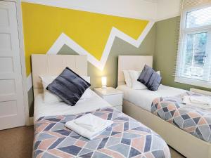 剑桥Epicsa - 3 Bedroom Family & Corporate Stay, Garden and FREE parking的一间带两张床的卧室和一堵山景墙