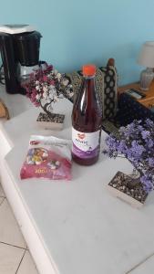 阿斯特里斯Giola aparments and studios 2的一瓶苏打水坐在开满鲜花的柜台上