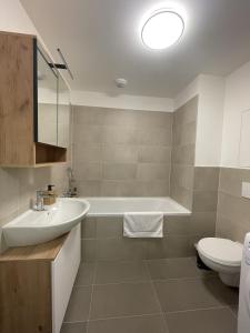 布拉迪斯拉发SkyNest A204的带浴缸、盥洗盆和卫生间的浴室