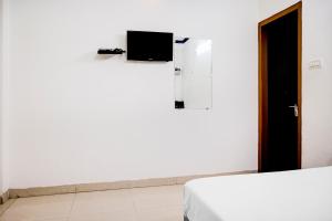 瓦拉纳西Flagship Hotel Lotus Inn的客房设有两张床和一台墙上的电视。