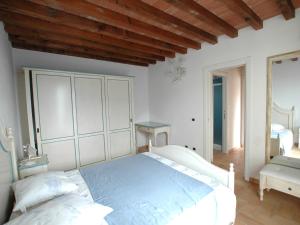 里奥马里纳Villaggio Di Mezzo Ortano的卧室设有白色的床和木制天花板。