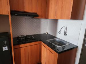 万隆Metro Suits Apartment Bandung的厨房配有水槽和炉灶