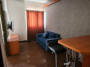 万隆Metro Suits Apartment Bandung的客厅配有蓝色的沙发和桌子