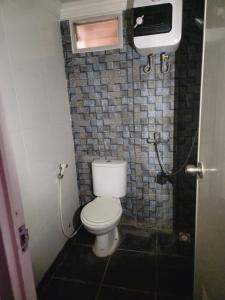 万隆Metro Suits Apartment Bandung的一间带卫生间和瓷砖墙的浴室