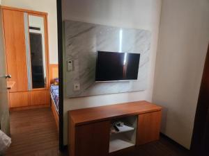 万隆Metro Suits Apartment Bandung的墙上配有平面电视的房间