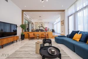 阿布扎比AYA Boutique - Oasis in Al Muntazah 3BR Villa with Private Pool的客厅配有蓝色的沙发和电视