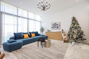 阿布扎比AYA Boutique - Oasis in Al Muntazah 3BR Villa with Private Pool的客厅配有蓝色的沙发和圣诞树