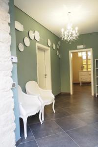 科米索Terrazzani Suite的一间配备有白色椅子和吊灯的餐厅