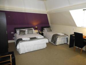 布莱克伍德梅斯庄园乡村酒店的酒店客房设有两张床和窗户。