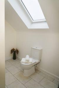 纽尼顿Luxury 4Bed Townhouse - Parking+Wi-Fi+Amenities的白色的浴室设有天窗和卫生间。