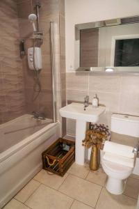 纽尼顿Luxury 4Bed Townhouse - Parking+Wi-Fi+Amenities的浴室配有卫生间、盥洗盆和浴缸。