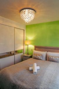 纽尼顿Luxury 4Bed Townhouse - Parking+Wi-Fi+Amenities的绿色卧室配有一张大床,上面有毛巾