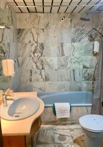 马亚美洲狮旅馆的一间带水槽和浴缸的浴室