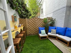 切尔滕纳姆Cambray Apartment的一个小庭院配有椅子和蓝色枕头