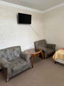 努库斯Guest house "NIKA", Nukus的客厅配有沙发、椅子和电视