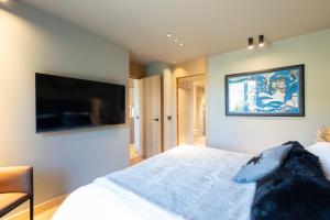 埃尔塔特W ISARD LODGE by Select Rentals的卧室配有一张床,墙上配有电视。