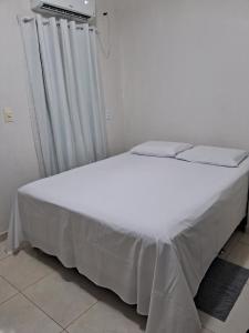 皮拉尼亚斯Suítes flor de Mandacaru的卧室配有白色床单和白色床。