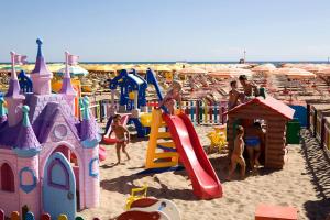 里米尼Hotel Bella Romagna的一群儿童在海滩上的游乐场玩耍