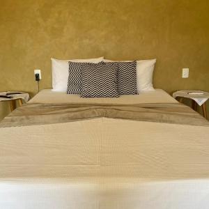 瓜拉派瑞Pousada Peninsula Santa Rita的卧室设有一张大床和两张桌子