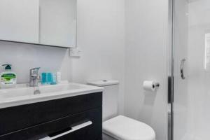 奥克兰Urban Thrive Studio is in a great location的白色的浴室设有水槽和卫生间。
