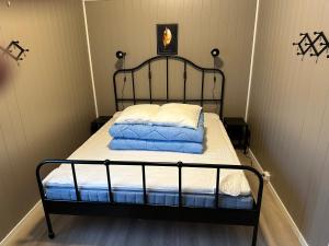 GrongLangnes Camping, Grong的一张带黑色框架和白色床单及枕头的床