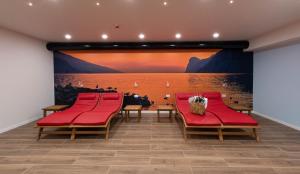 加尔达湖滨GARNI' FOCI的一间设有红色椅子和大型壁画的等候室