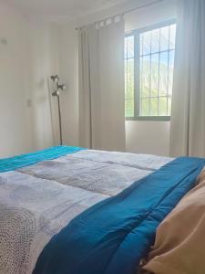 坎昆CASA CORAZA的一间卧室配有一张蓝色的床和窗户