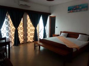 马哈赞加RAOOF HOTEL的一间卧室配有床和带窗帘的窗户