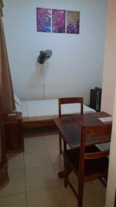 马哈赞加RAOOF HOTEL的配有一张桌子和一部电话的长凳的房间
