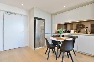 悉尼Chic Zenith Retreat -Vista, Skylight, Parking的厨房配有桌椅和冰箱。