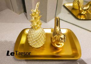 泗水Le Tresor Benson Apartment at Supermal Pakuwon的上面有 ⁇ 萝的金盘