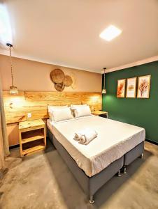 阿拉卡茹Vila Aju - Pousada Temática的一间卧室设有一张大床和绿色的墙壁