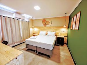 阿拉卡茹Vila Aju - Pousada Temática的一间卧室设有一张床和绿色的墙壁