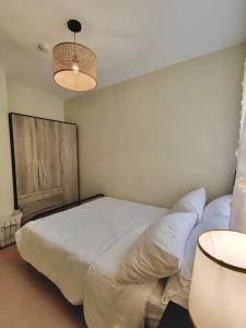 杜马格特Ezzel’s Place at Marina Spatial Dumaguete City的卧室配有一张白色大床和两盏灯。