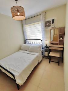 杜马格特Ezzel’s Place at Marina Spatial Dumaguete City的一间卧室配有一张床、一张桌子和一面镜子
