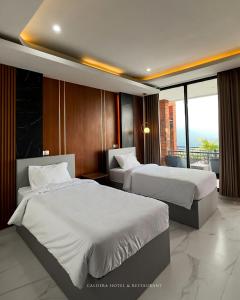 金塔马尼caldera hotel的酒店客房设有两张床和一个阳台。