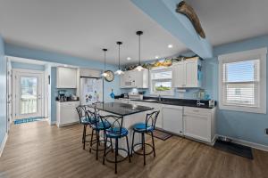奇蒂豪克R Beach House的厨房配有白色橱柜和蓝色的墙壁