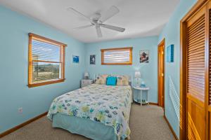 奇蒂豪克R Beach House的蓝色卧室配有床和吊扇