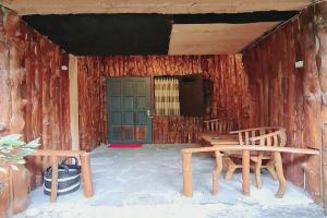 KalirejoLarasati Homestay的门廊配有2把木椅和绿门