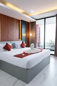 金塔马尼caldera hotel的卧室配有带红色枕头的大型白色床