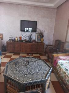 马拉喀什Villa Générosité的客厅配有电视和桌子