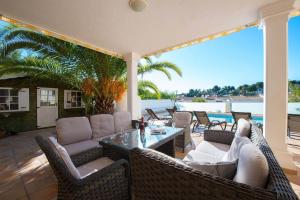 莫莱拉Villa Malibu - PlusHolidays的庭院配有柳条家具和桌椅