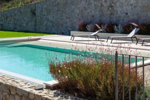 托尔托利Dimore Santa Justa的院子里的游泳池,带三把椅子和鲜花