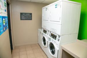 梅泰里Holiday Inn Metairie New Orleans, an IHG Hotel的洗衣房配有2台洗衣机和烘干机