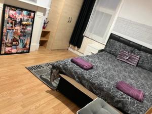 伦敦Comfy rooms. Shared East London Homestay.的一间卧室配有一张带紫色枕头的床