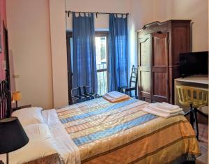 蒙泰蒙阿科拉奇塔代拉迪蒙蒂锡比利尼旅馆的一间卧室配有一张带蓝色窗帘的床和一扇窗户